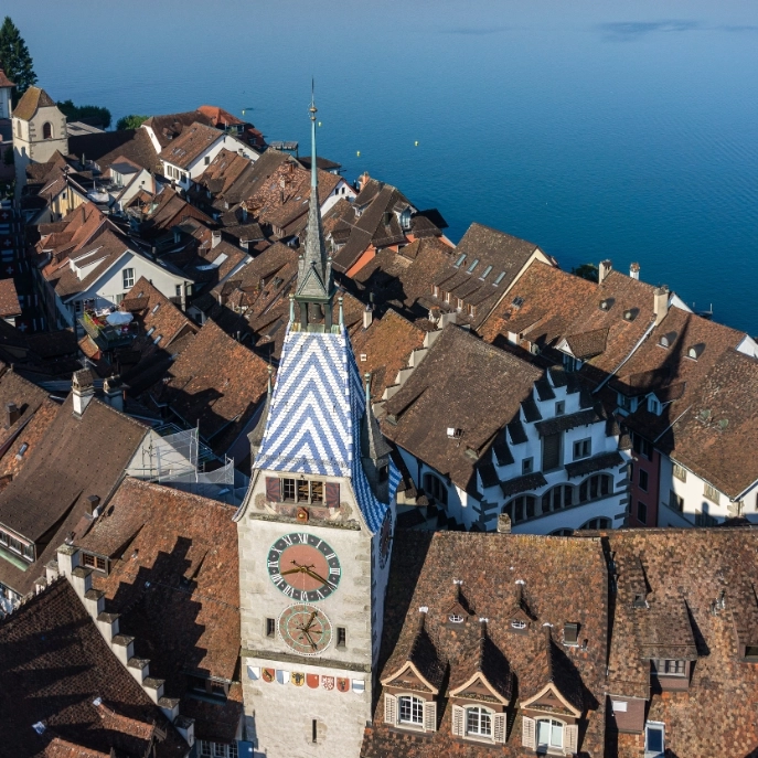 Ansicht des Zytturm von oben mit dem blauen und weissen Dach und Blick in die Altstadt mit See im Hintergrund